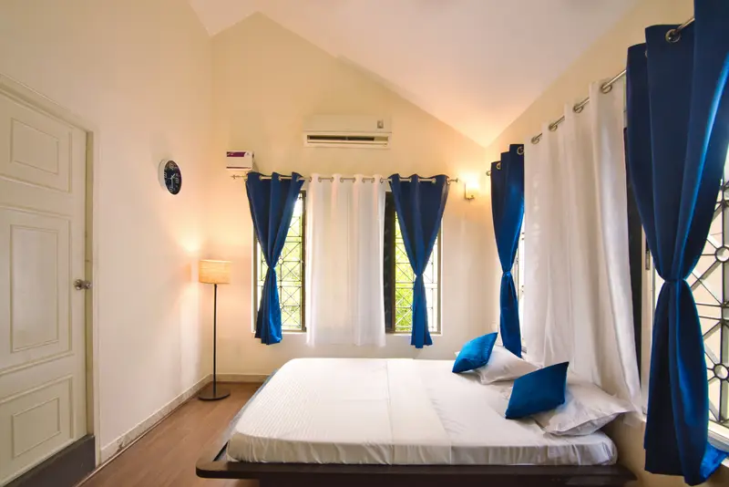 An air-conditioned bedroom with blue curtains