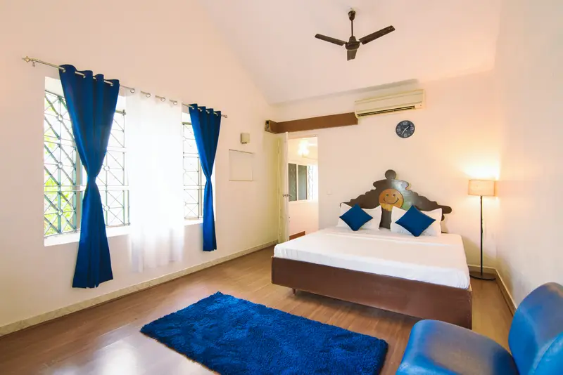 A bedroom with a wooden floor and a dark-wood bed