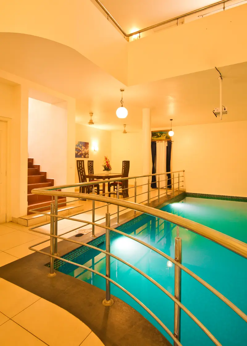 The indoor pool seen from the landing, with the dining table beyond